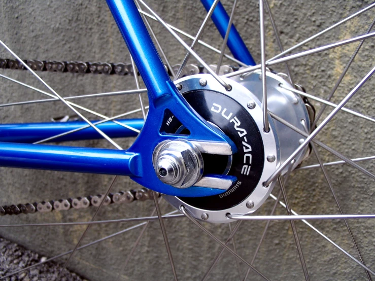 a close up of the spokes of a blue bicycle