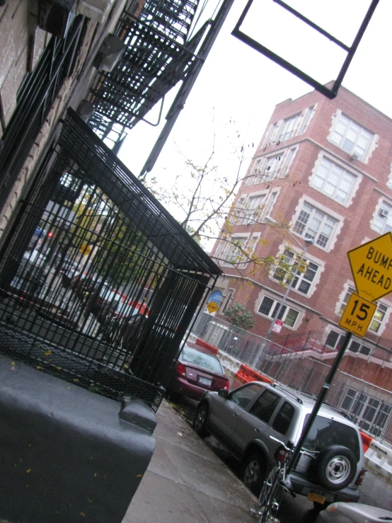 a metal fence sits next to some cars on a street