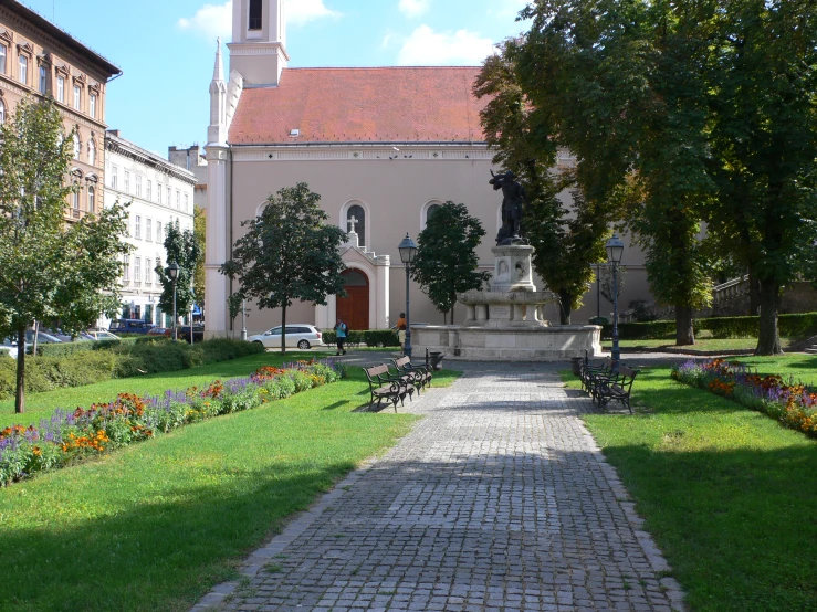 the path is lined with flowers next to the building