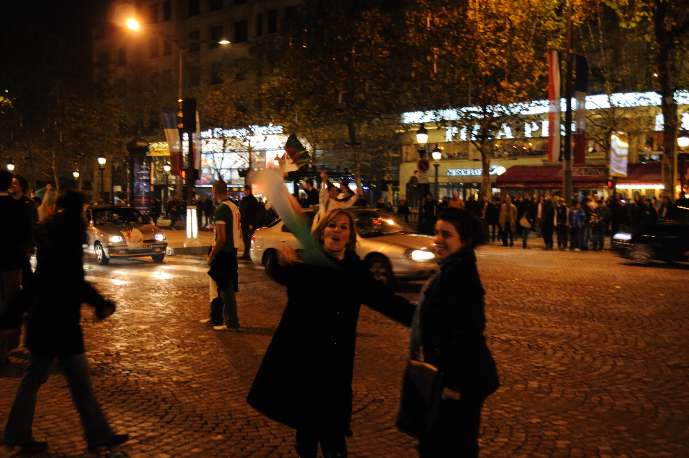 two women dancing in the middle of the city at night