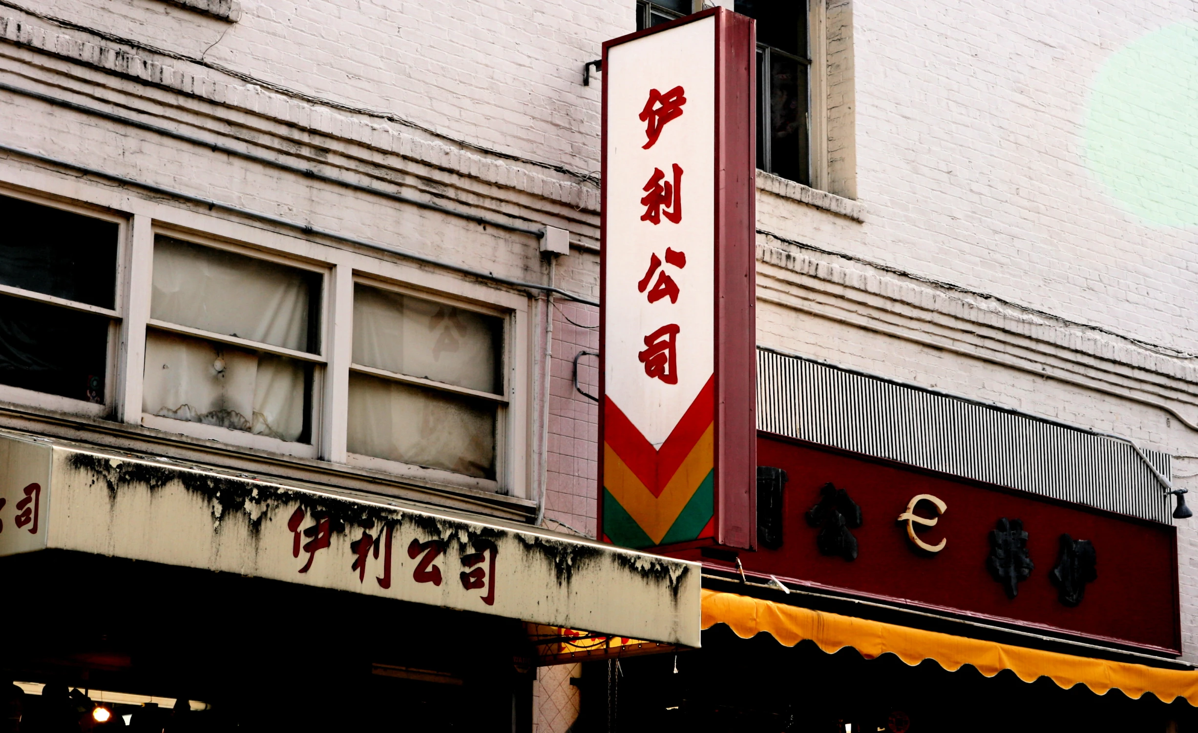 the corner of an asian restaurant with chinese writing on the side