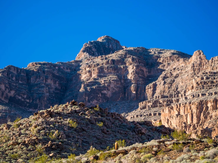 large rocks are next to a mountain side