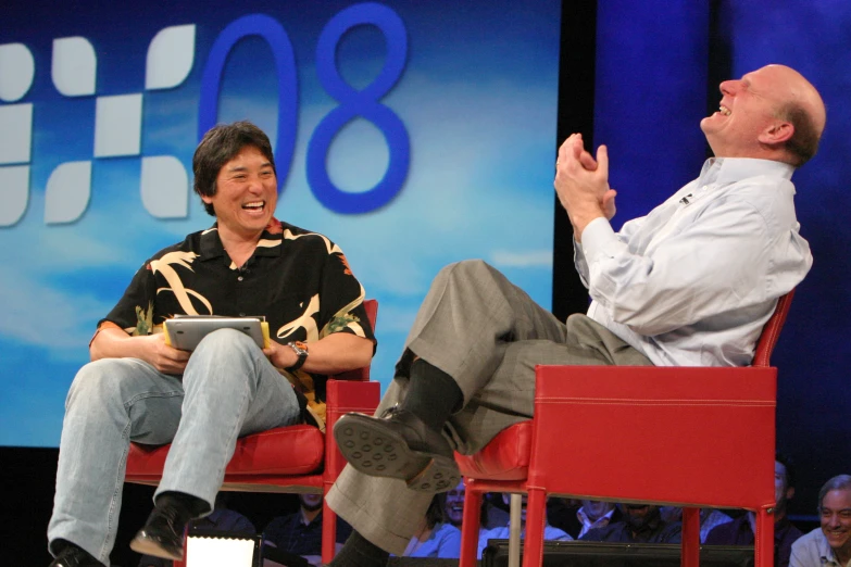 a couple of men sitting in chairs talking