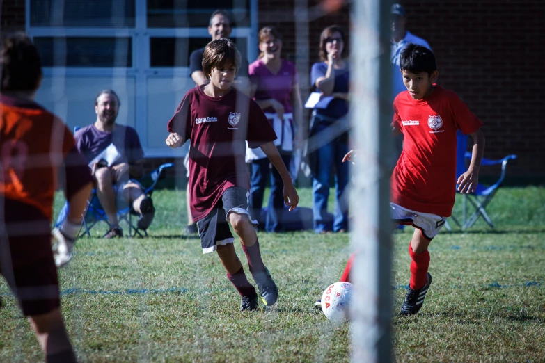 a couple of boys kicking around a soccer ball on a field