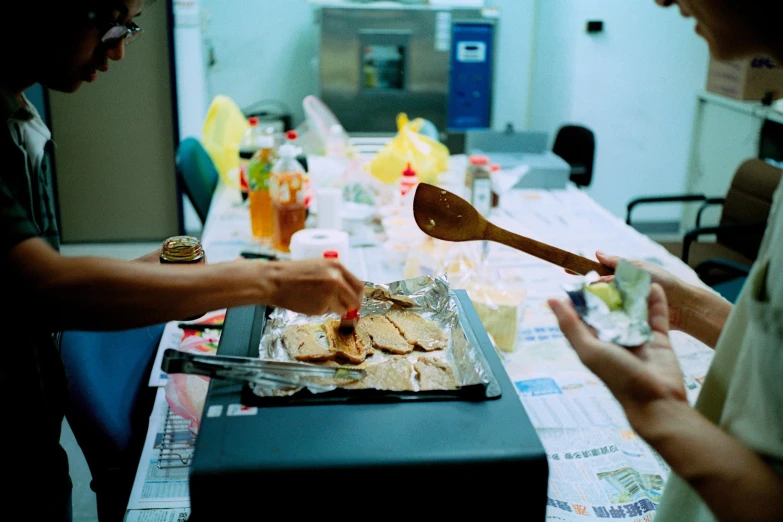 three people are serving themselves food at a table