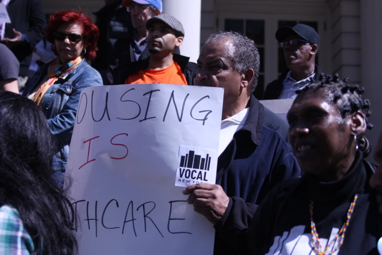 a man with an anti - hurricane sign stands near a crowd