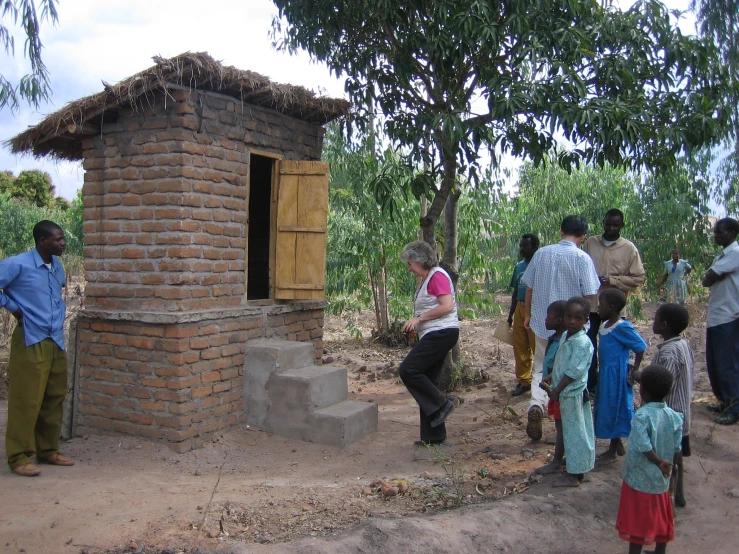 a group of people standing around a brick building