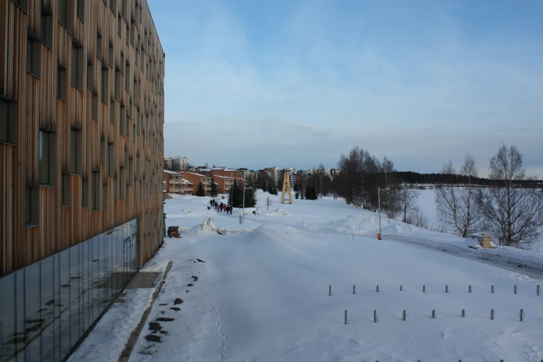 a snow covered street next to a tall building