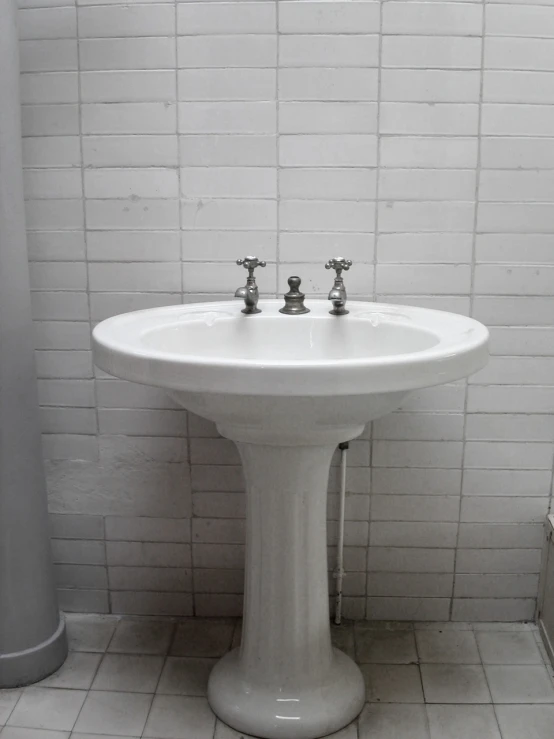 a white sink in the corner of a bathroom