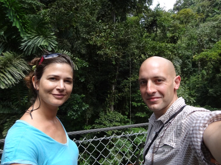 a man and woman taking a picture of a jungle