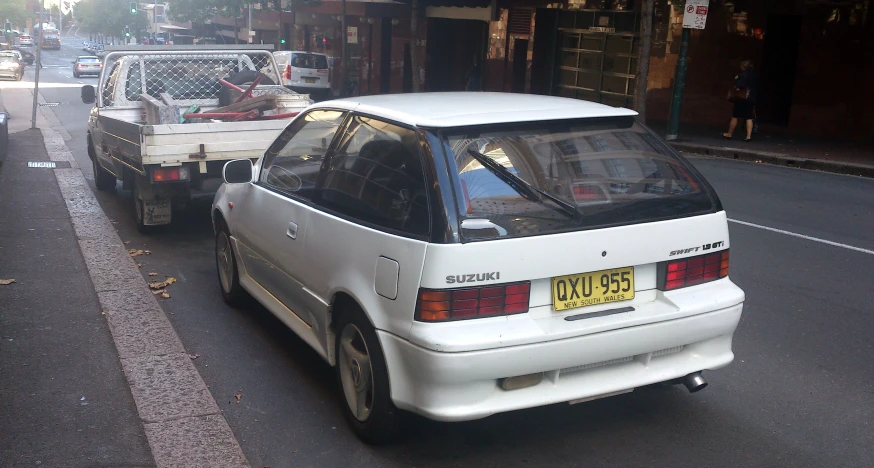 there is a white toyota car driving on the street