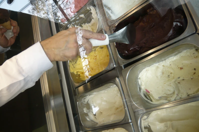 a chef in a white jacket serving food out of trays