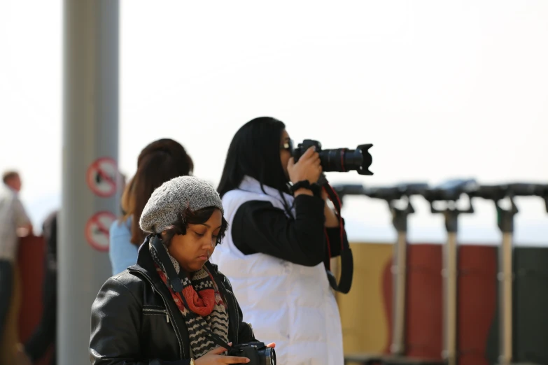 a person looking at a po while a girl looks on with a camera