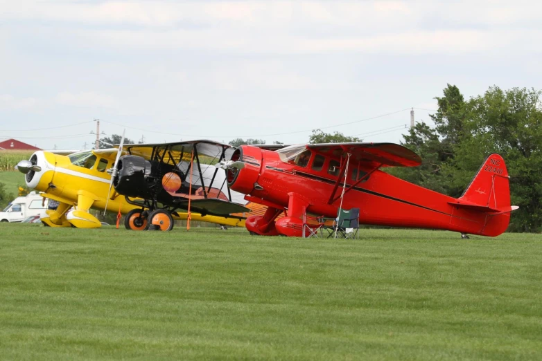 two airplanes with black and yellow engines sit on grass