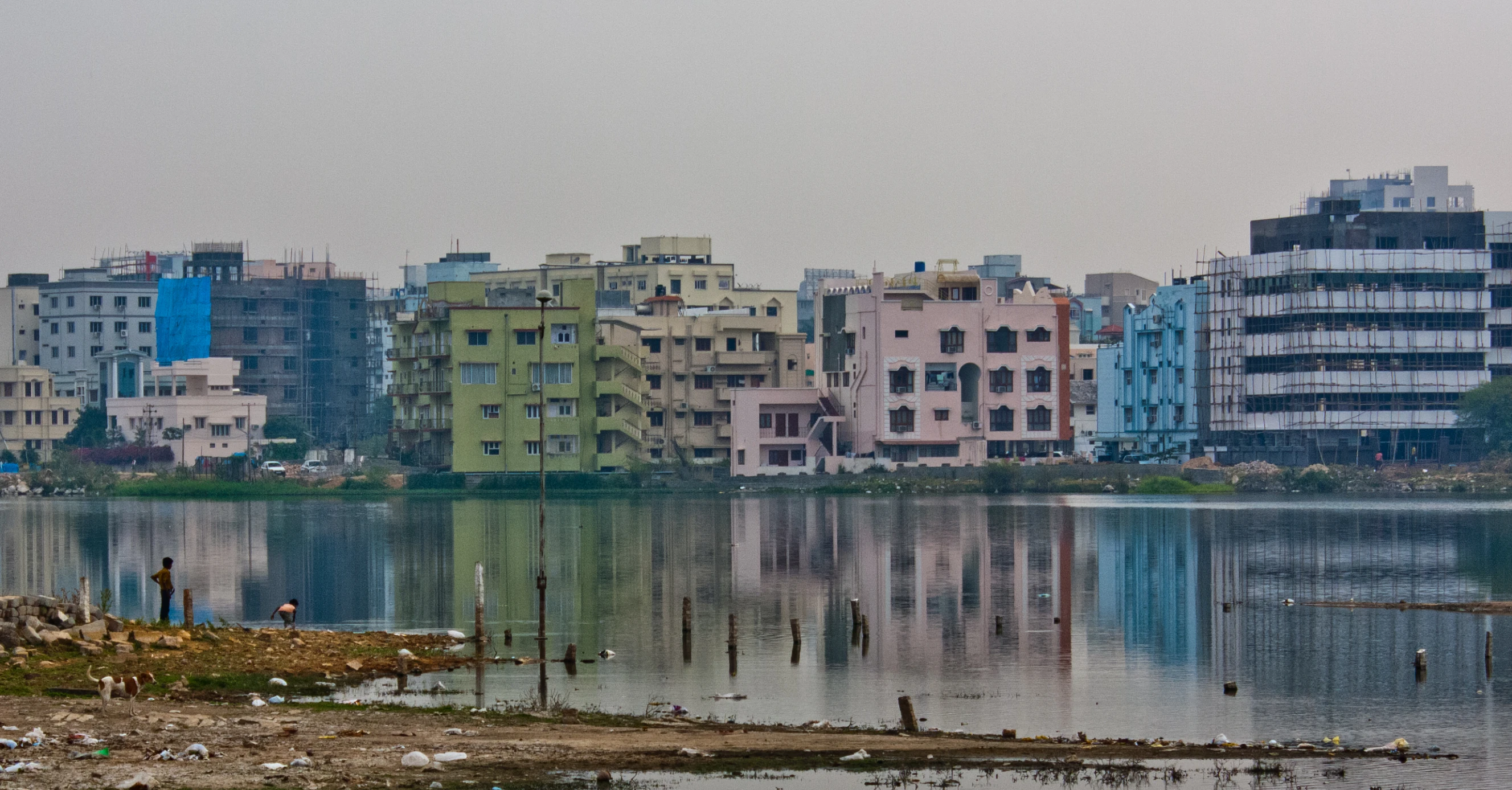 a city with large buildings is seen across a body of water