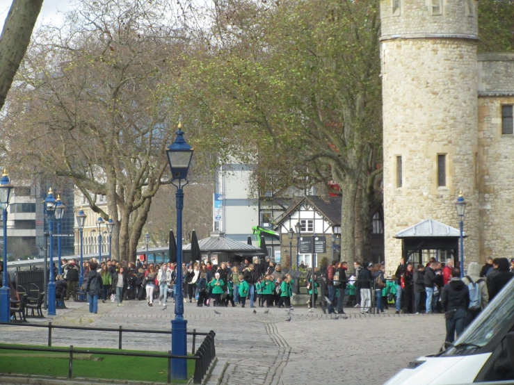 many people are gathered around a plaza in an old town