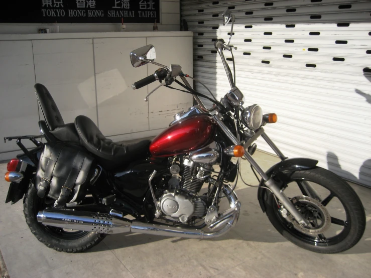 a red motorcycle is parked outside a garage