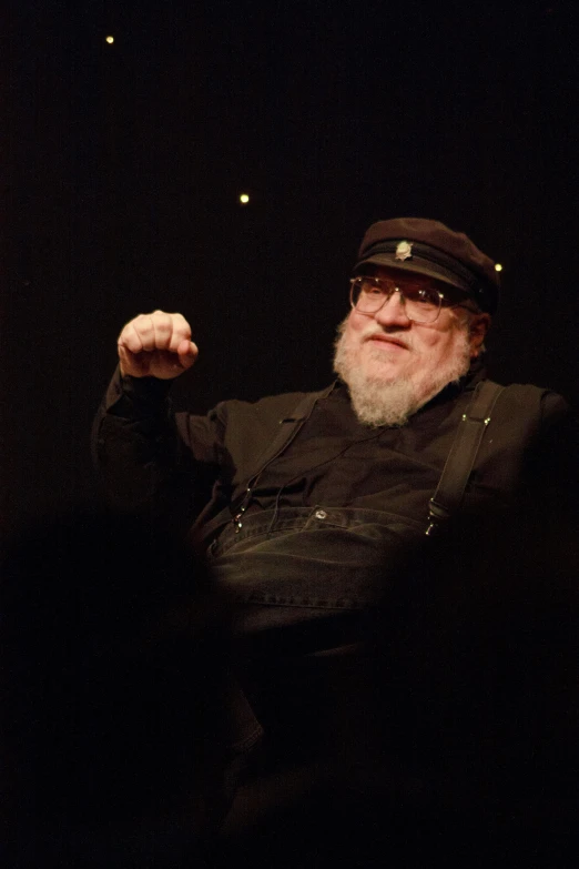 an old man wearing glasses sitting in a chair