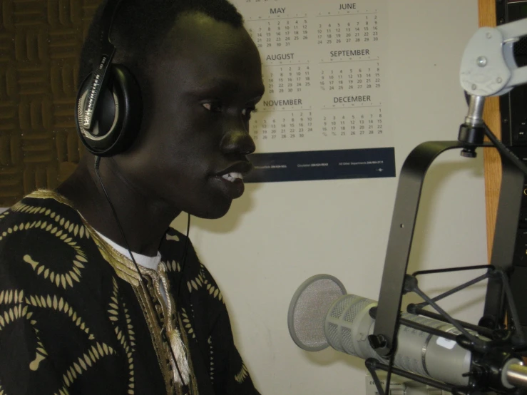 a black woman wearing headphones while sitting in front of a microphone