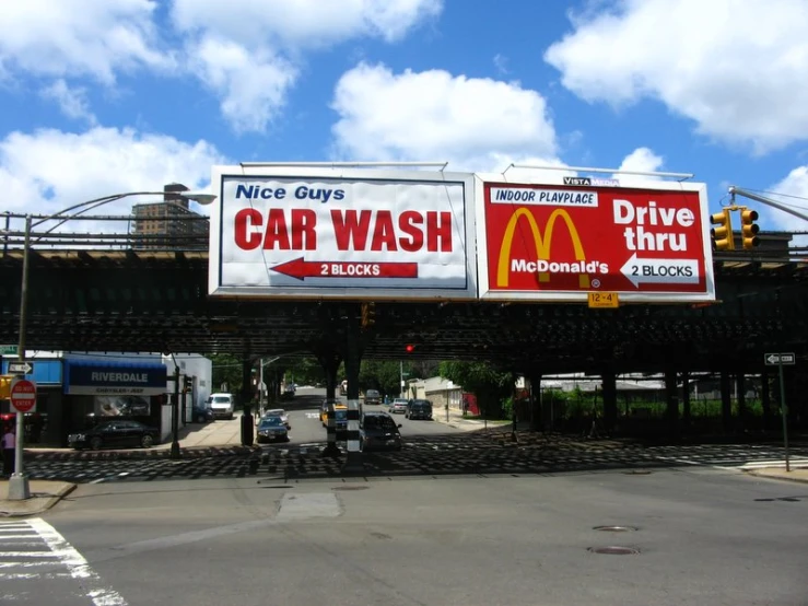 a few billboards on the road advertising a service station