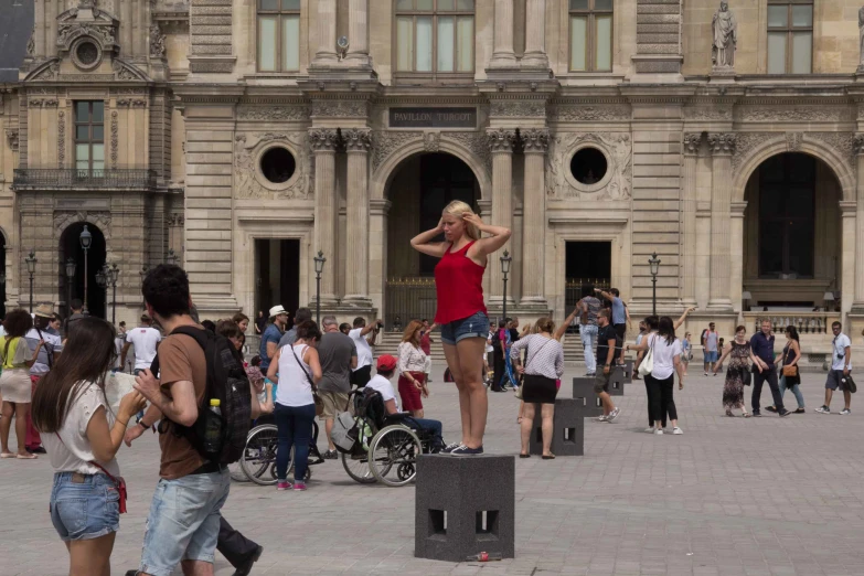 several people stand near a building with a man on a cell phone