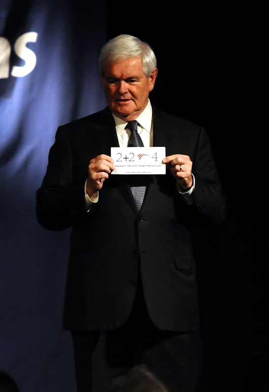 a man holds up a piece of paper that reads obama