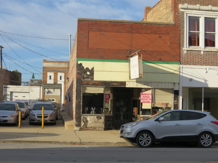 several cars parked in front of small store fronts