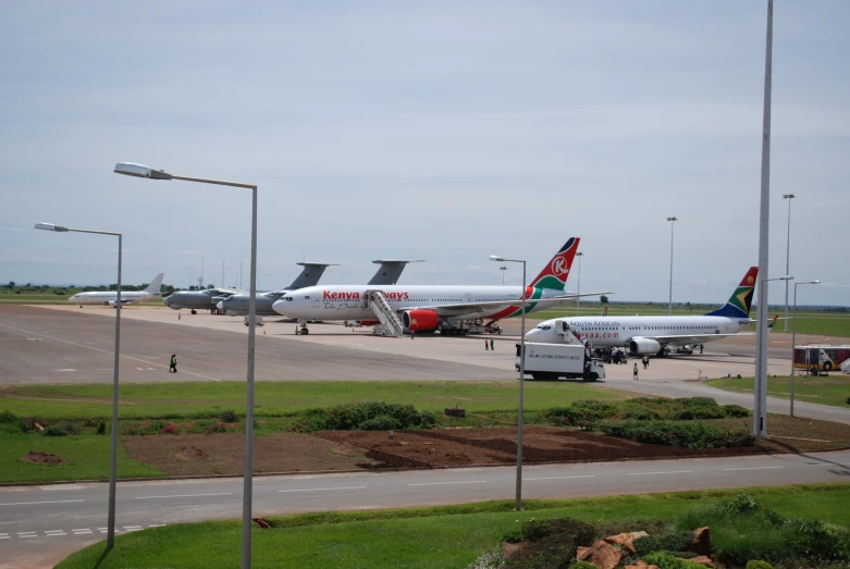 several jetliners parked on the side of the road in an airport