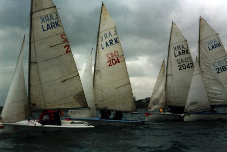 four sailboats are sailing in the open water