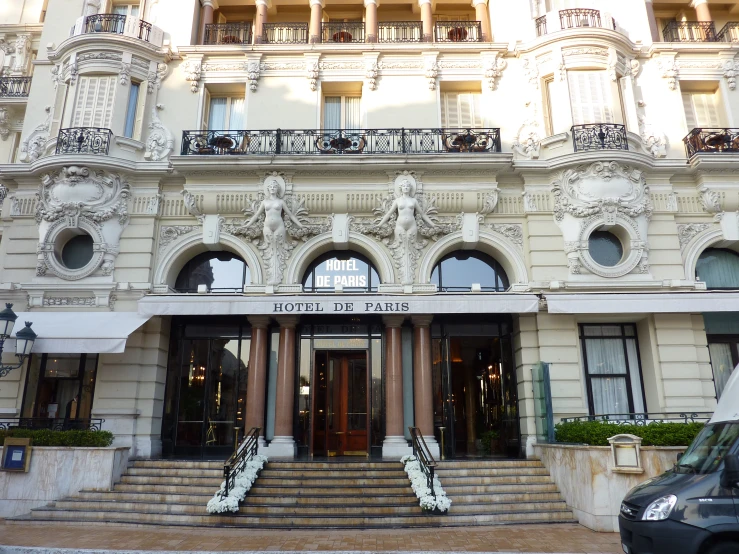 a tall white building with an ornate entrance and steps