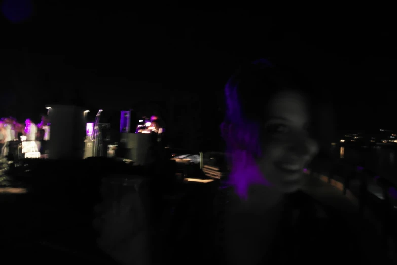 a woman with purple light shining on her and in the dark