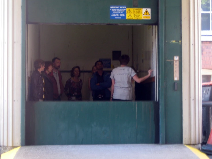 several people standing outside a door and entering