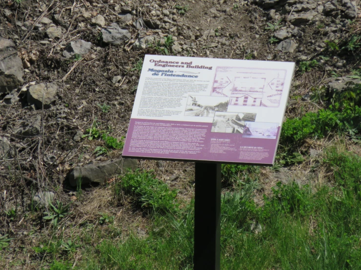 a sign is shown on the side of a grassy area