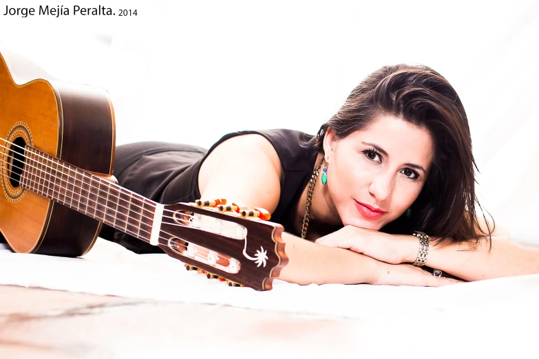 a woman posing with a ukulele on a bed