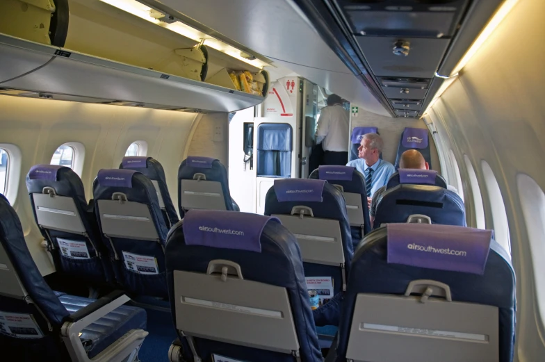 inside view of an airplane showing the seats and the back end of it