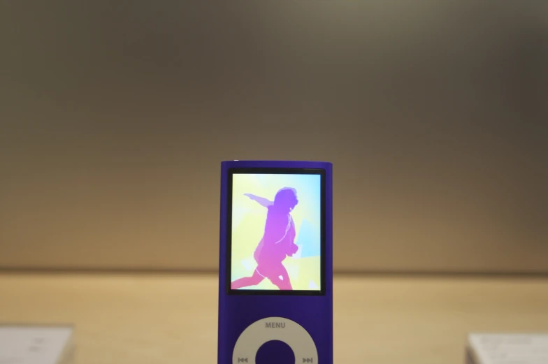 an ipod on top of a table with some sheets of paper in the background