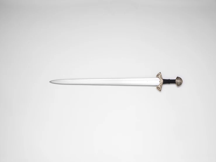 a black and white sword laying on a plain surface