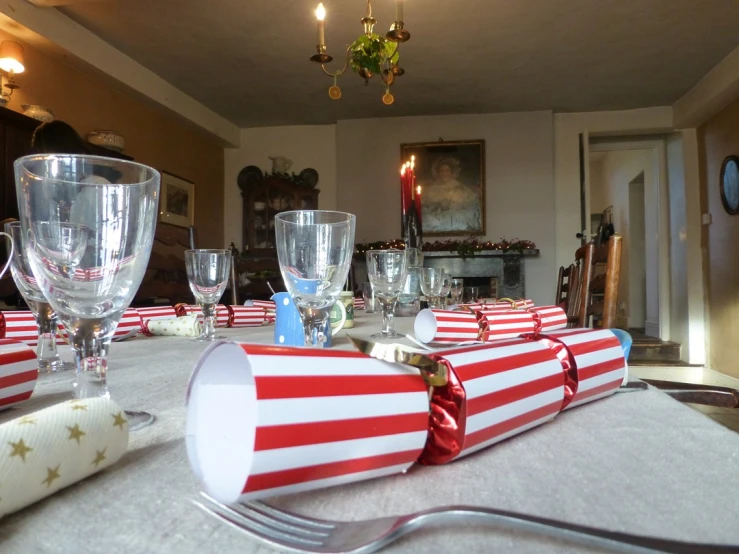 a long table has silverware and red stripe cups with gold stars