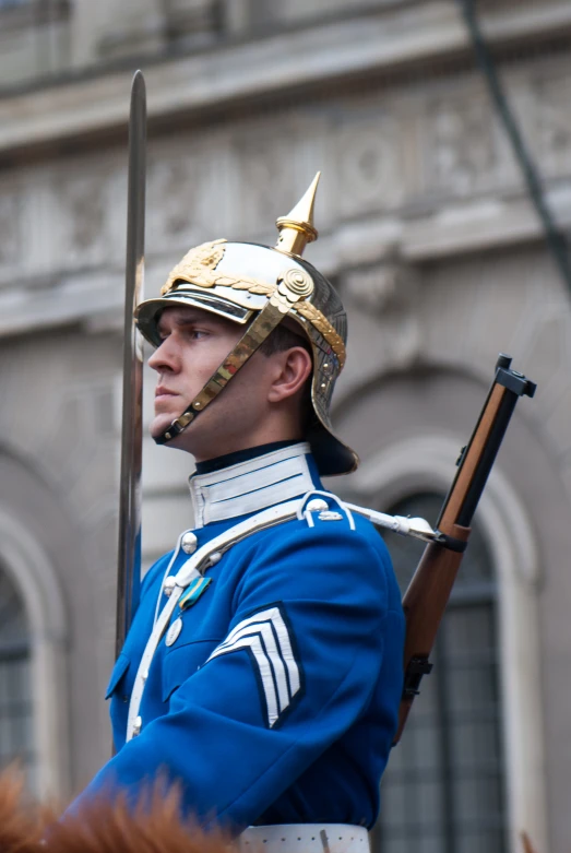 a man in a blue uniform is holding his rifle