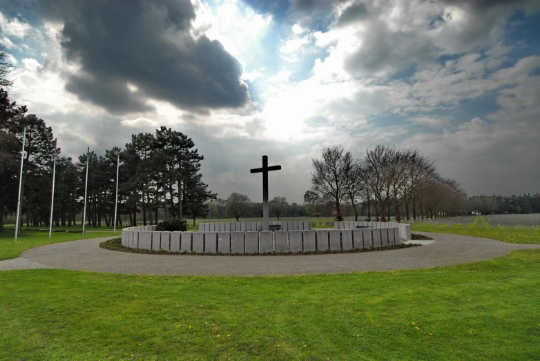 an outdoor memorial area with a cross on the center