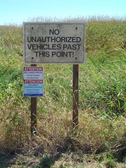 an unounted vehicle sign posted in the middle of a field