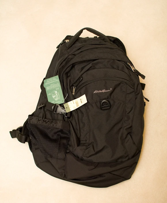 a black bag is sitting on the floor with an id tag