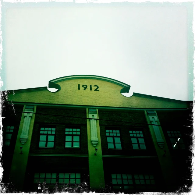 a green building with lots of windows and a clock