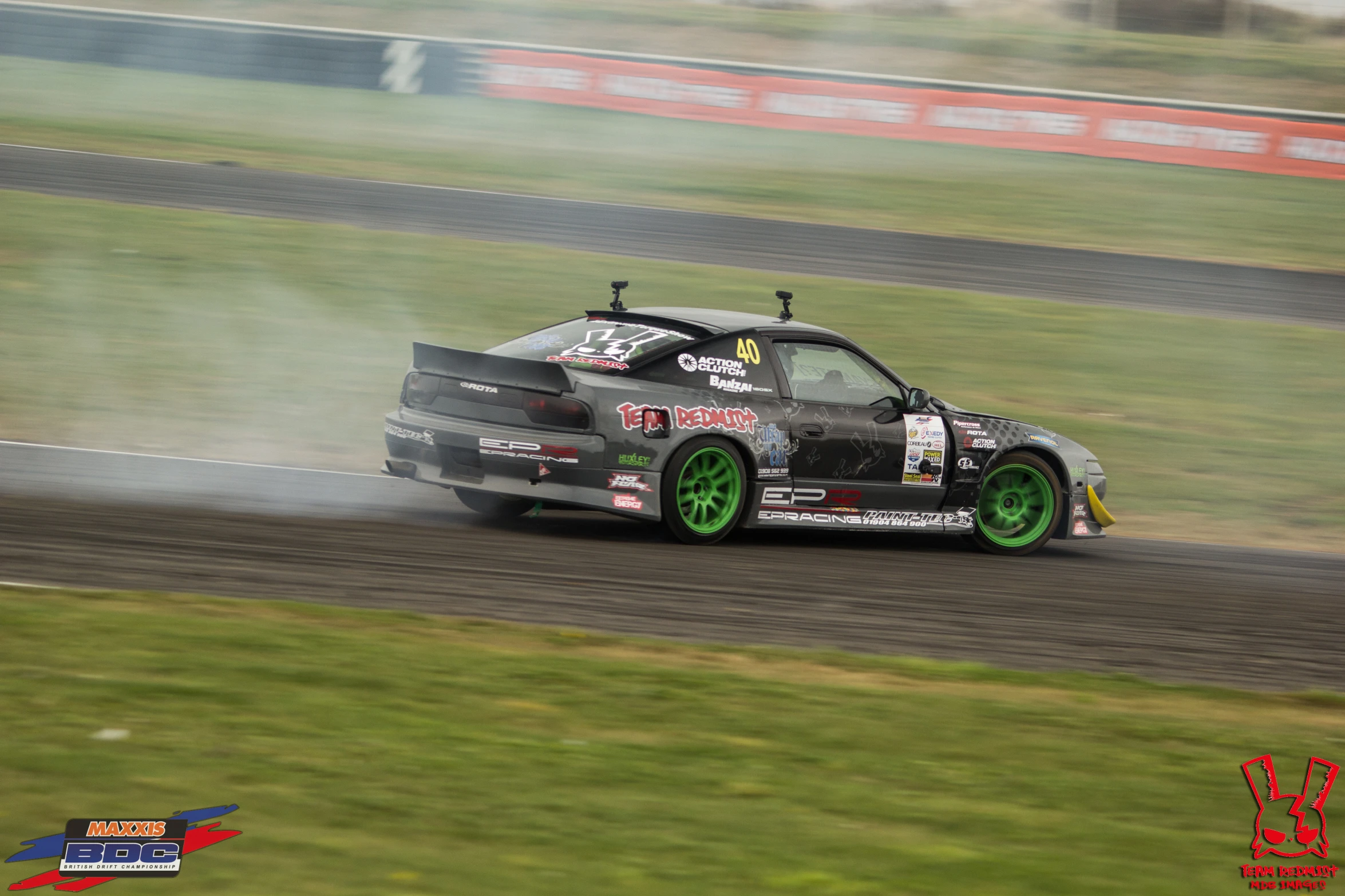 an automobile racing around a track on a foggy day