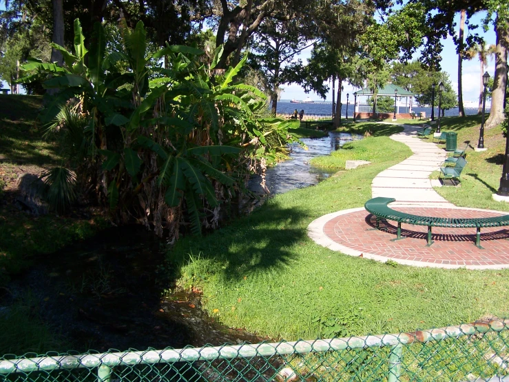 a park is lined with benches and lush green grass