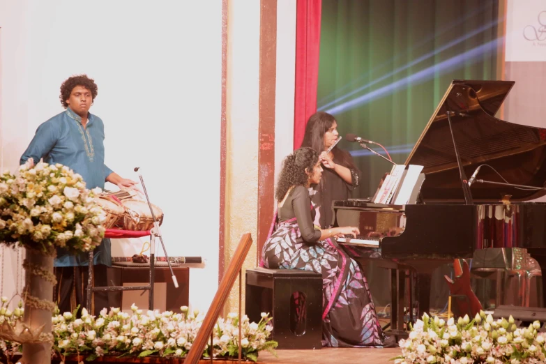 two people are on stage next to a piano and piano player