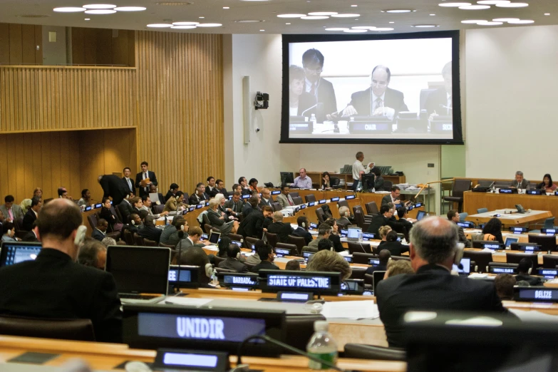 an audience watching people on their laptops at a conference