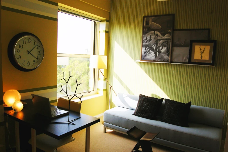 a living room with a couch and table next to a large clock