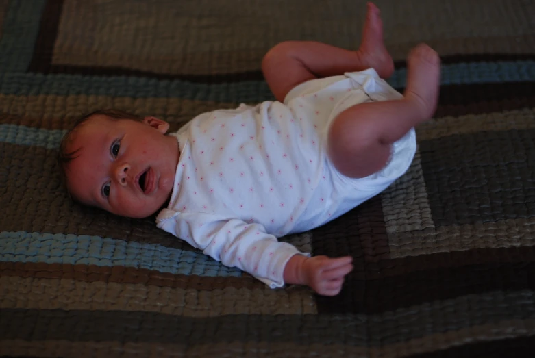 an adorable baby laying on the floor