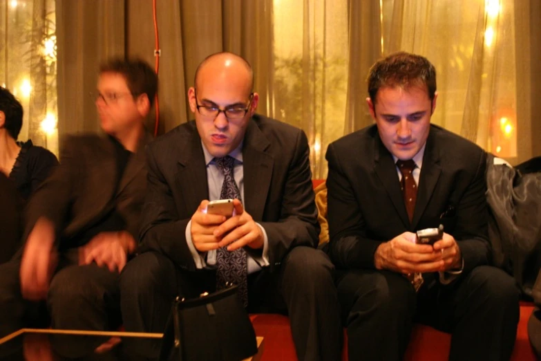 three businessmen in suits and ties sitting next to each other